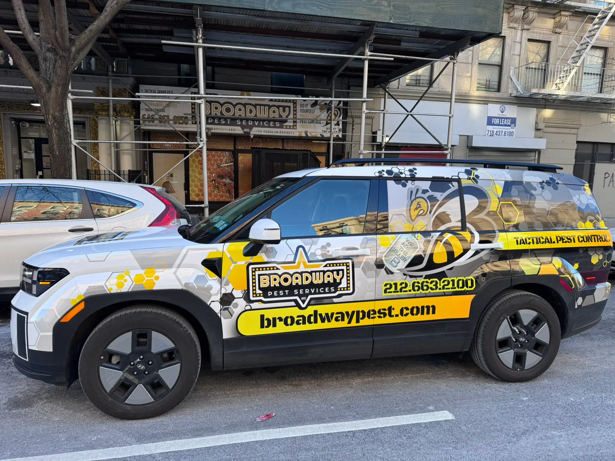 Broadway Pest Services Hyundai Santa Fe Hybrid service vehicle with full tactical wrap on NYC street